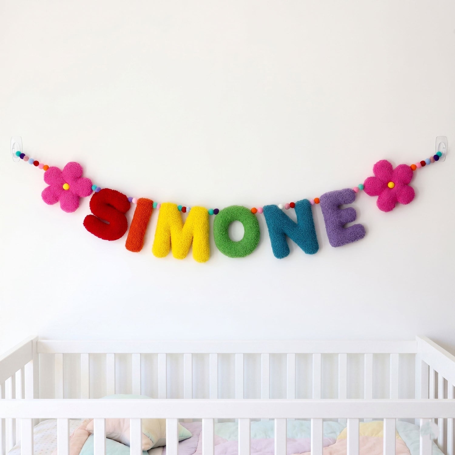 A collection of handmade personalized plush letter name banners and garlands for nursery wall decor.