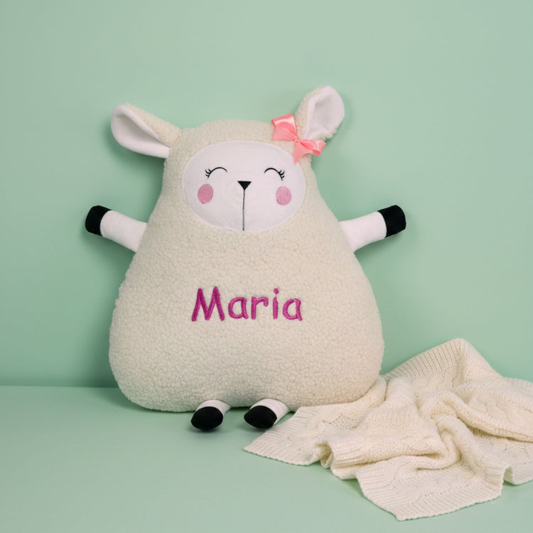 A variety of handmade personalized plush animal pillows with custom computer-embroidered names for nursery decor.