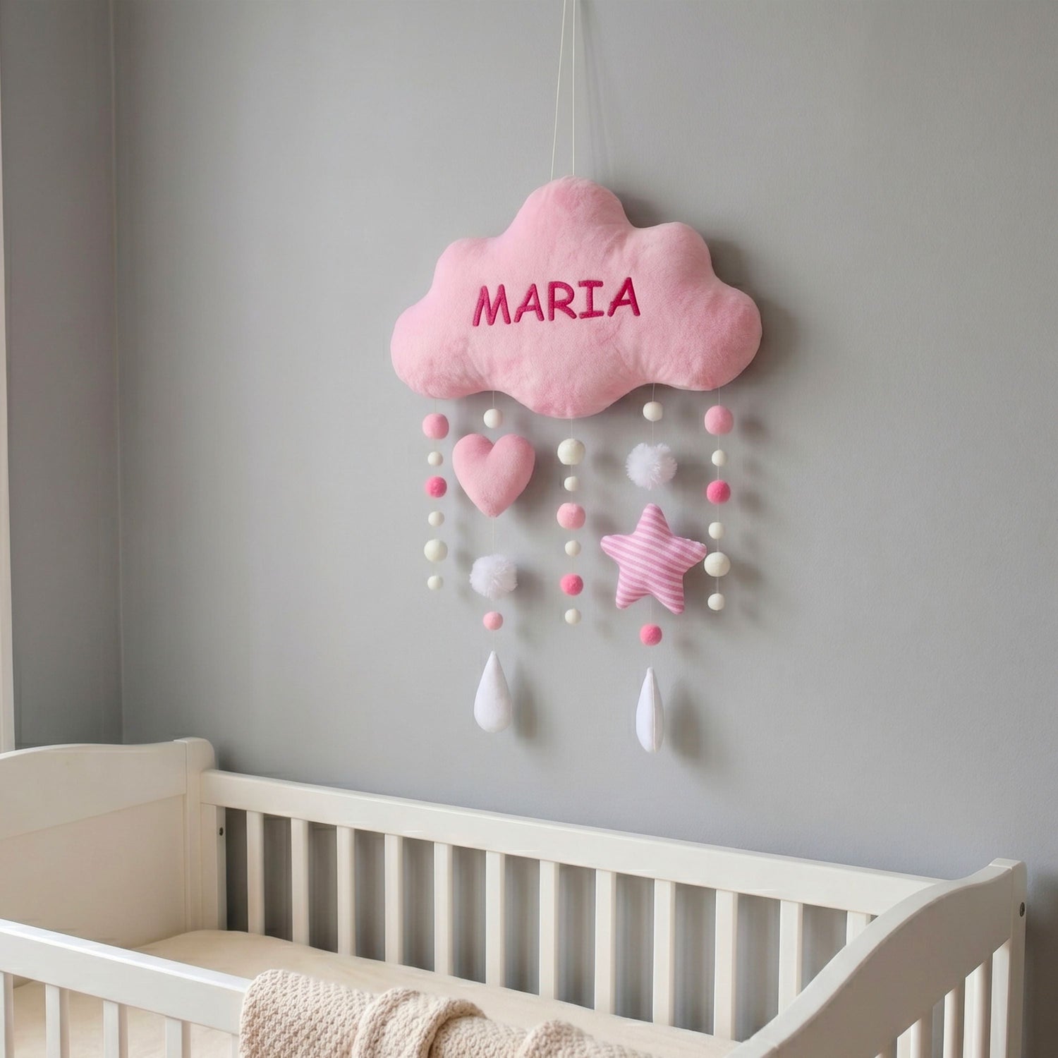Beautifully arranged personalized plush wall hangings and custom baby name banners decorating a cozy nursery wall.