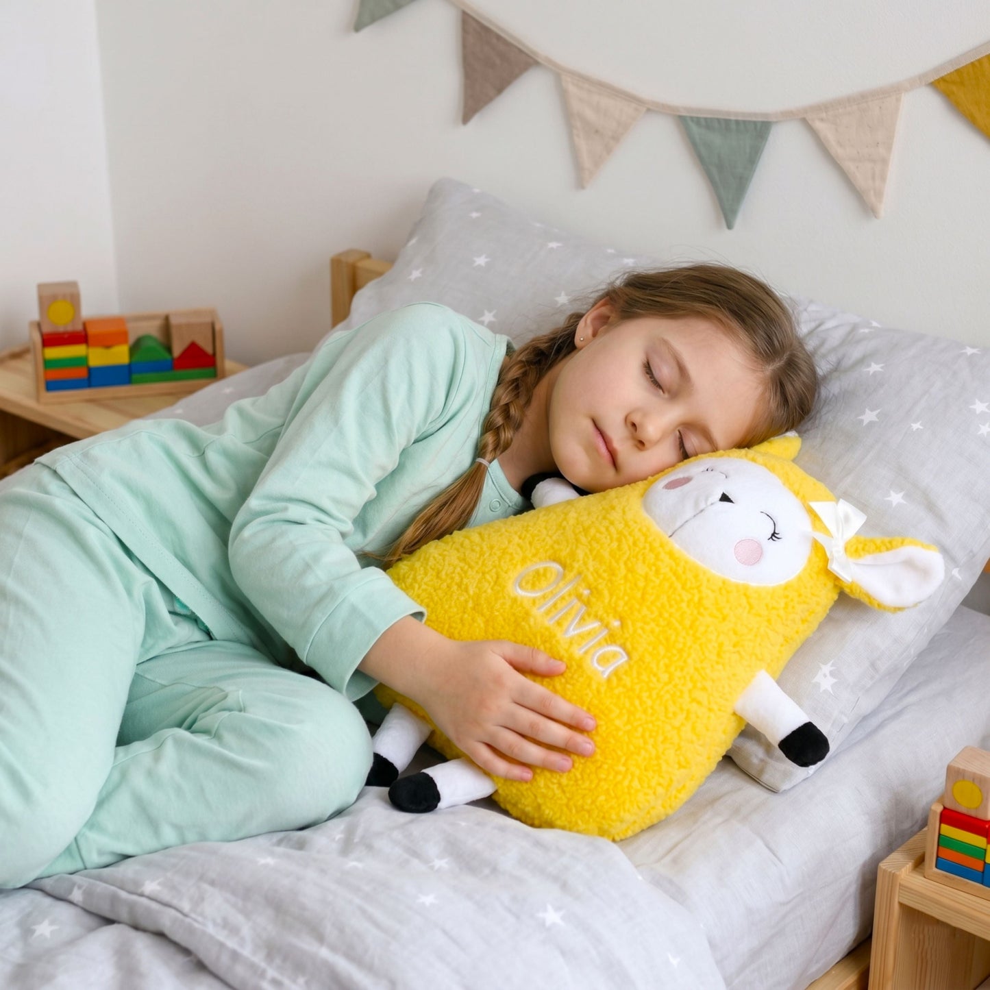 Child sleeping with a yellow sheep-shaped pillow in a bedroom setting