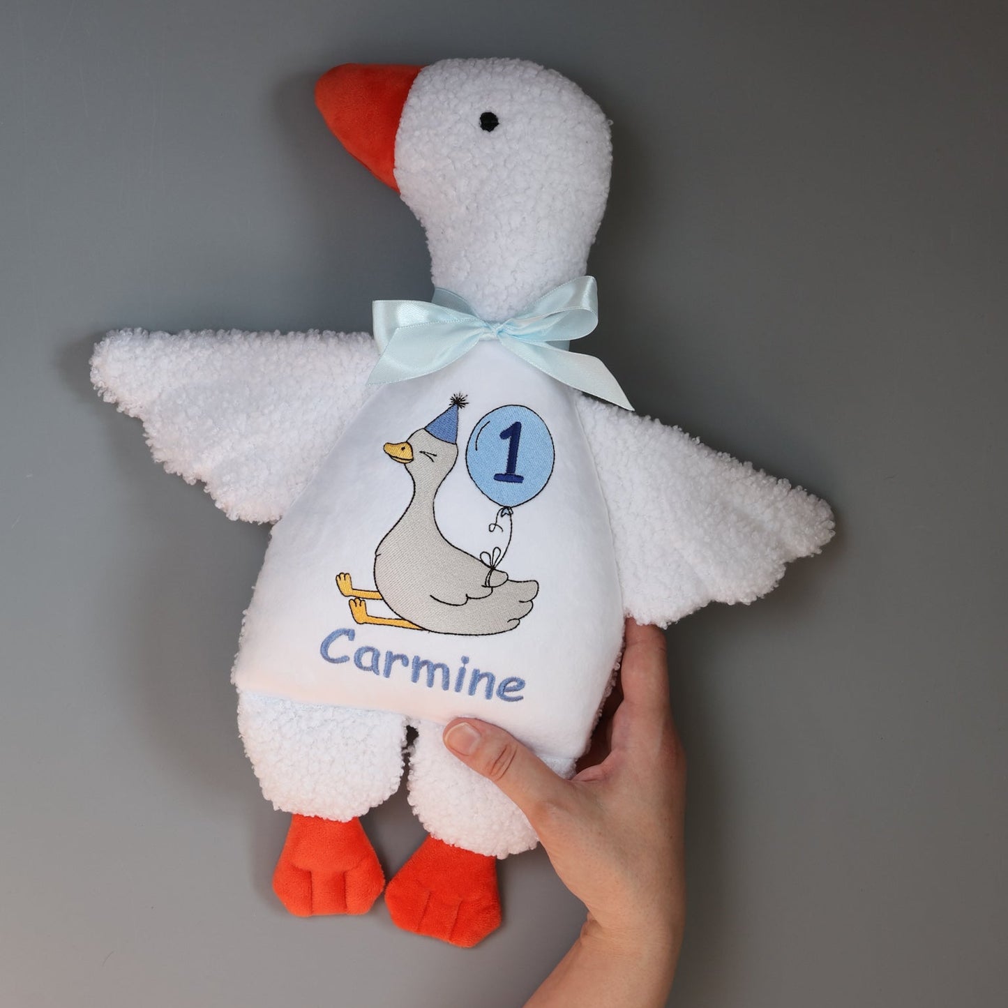 Product features of the custom embroidered birthday goose plush toy. Visual guide highlighting the personalized name feature and the custom birthday age balloon stitched on the soft toy's tummy.
