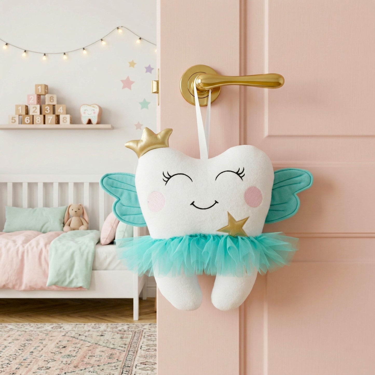 Decorative tooth-shaped plush toy with fairy wings hanging on a pink door in a child's bedroom.