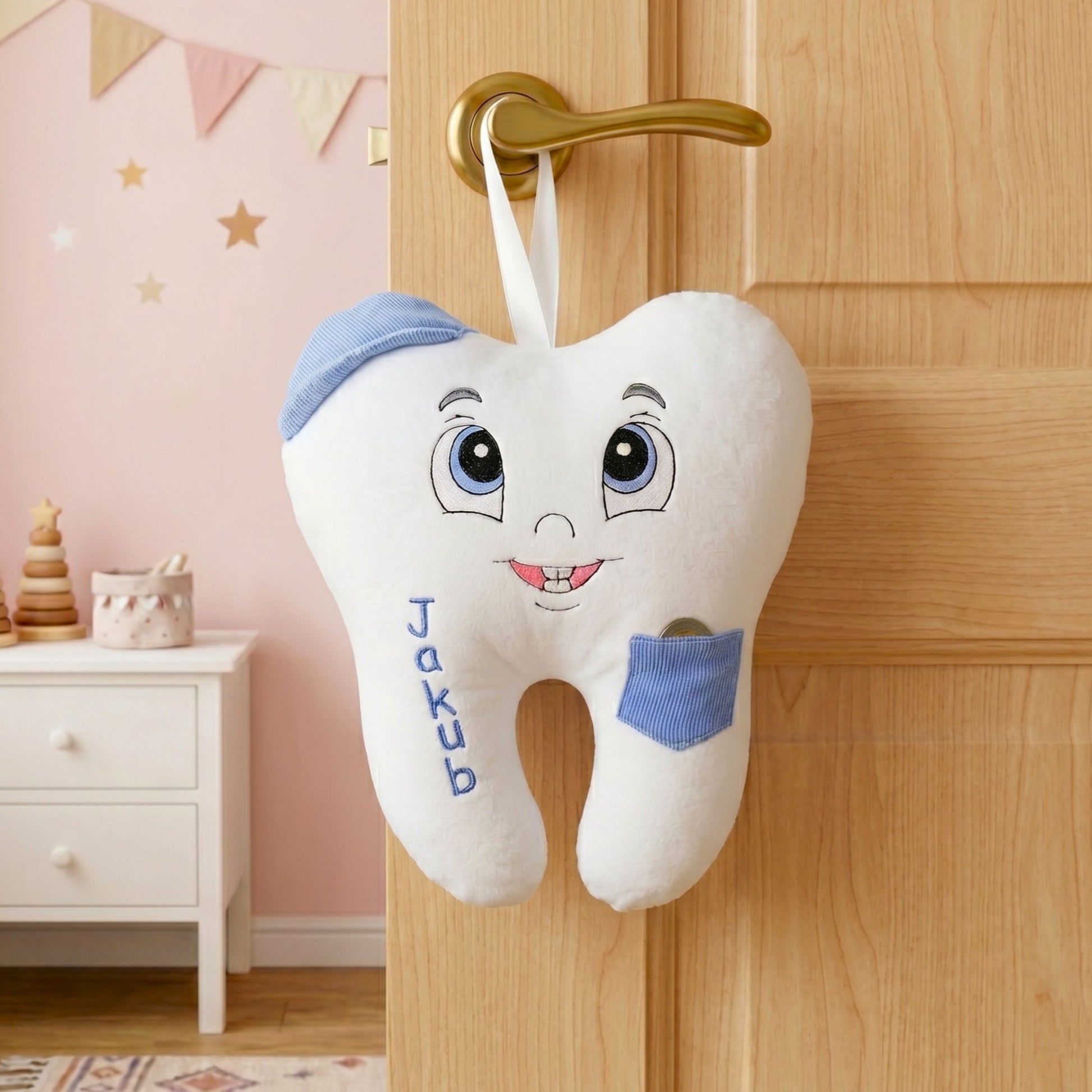 Plush tooth-shaped toy with a face hanging on a wooden door in a child's room.