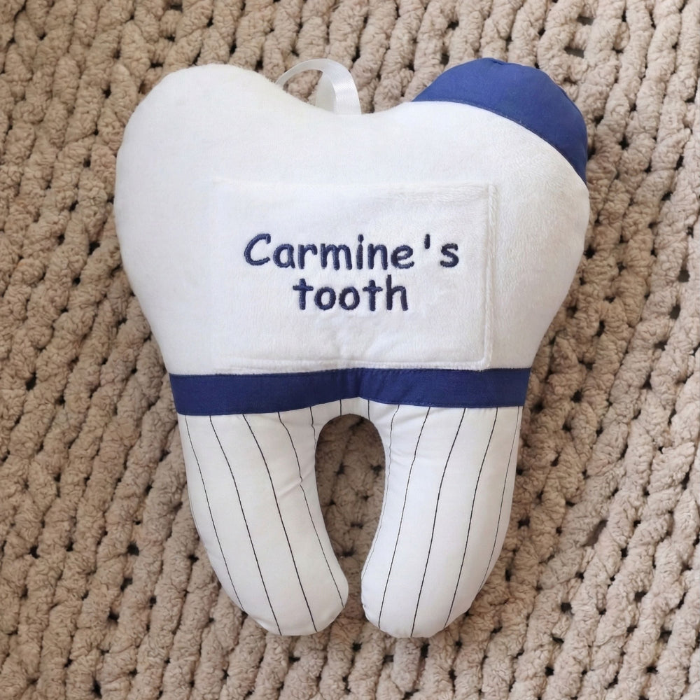 Tooth-shaped pillow with 'Carmine's tooth' text on a textured surface
