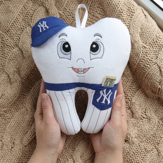 Toy tooth with a New York Yankees cap held by hands on a textured surface