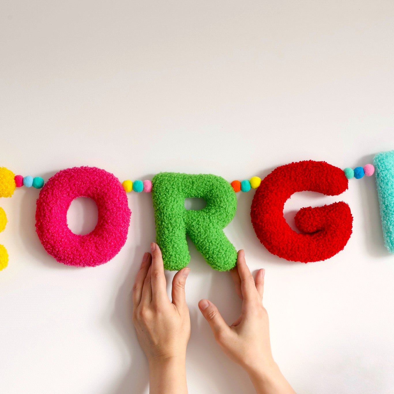 Colorful letter-shaped decorations spelling 'GEORGI' on a white background