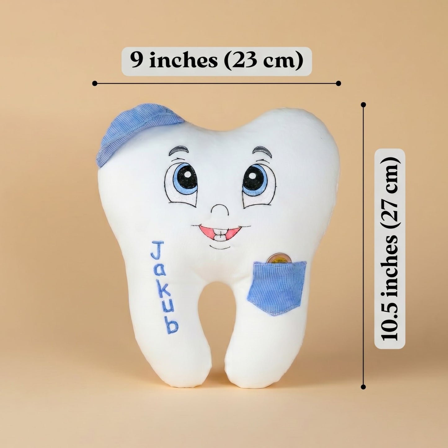 Plush tooth-shaped pillow with cartoon face, blue accents, and name 'Jakub' on a beige background with measurements.