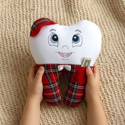Plush tooth-shaped toy with a red plaid outfit held by hands on a beige surface