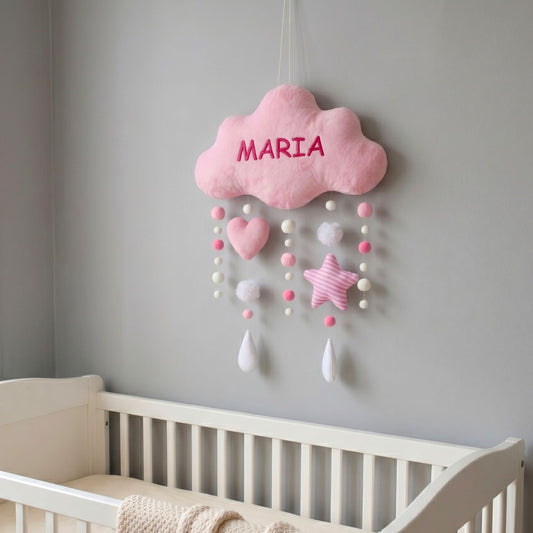 Pink cloud-shaped decoration on a gray wall above a crib.