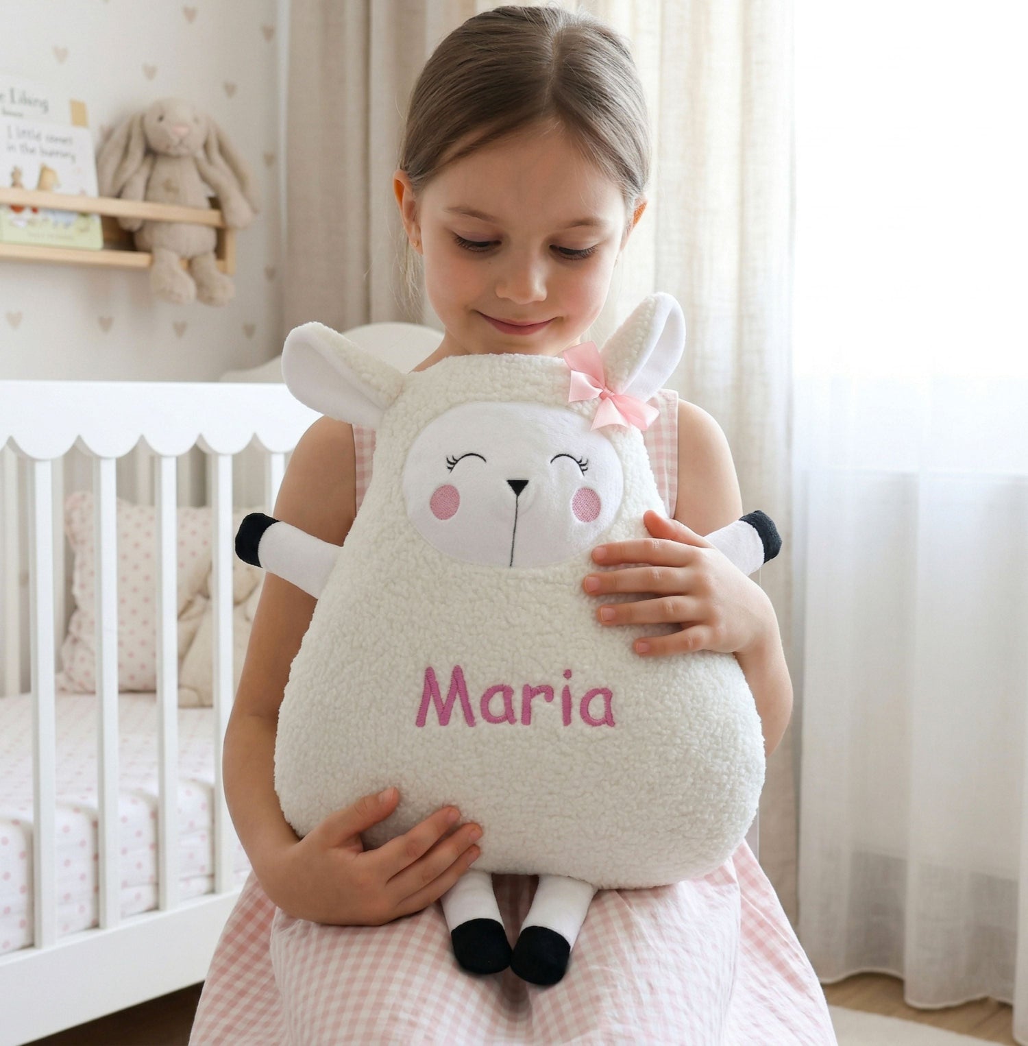 Child holding a plush sheep toy named 'Maria' in a nursery setting