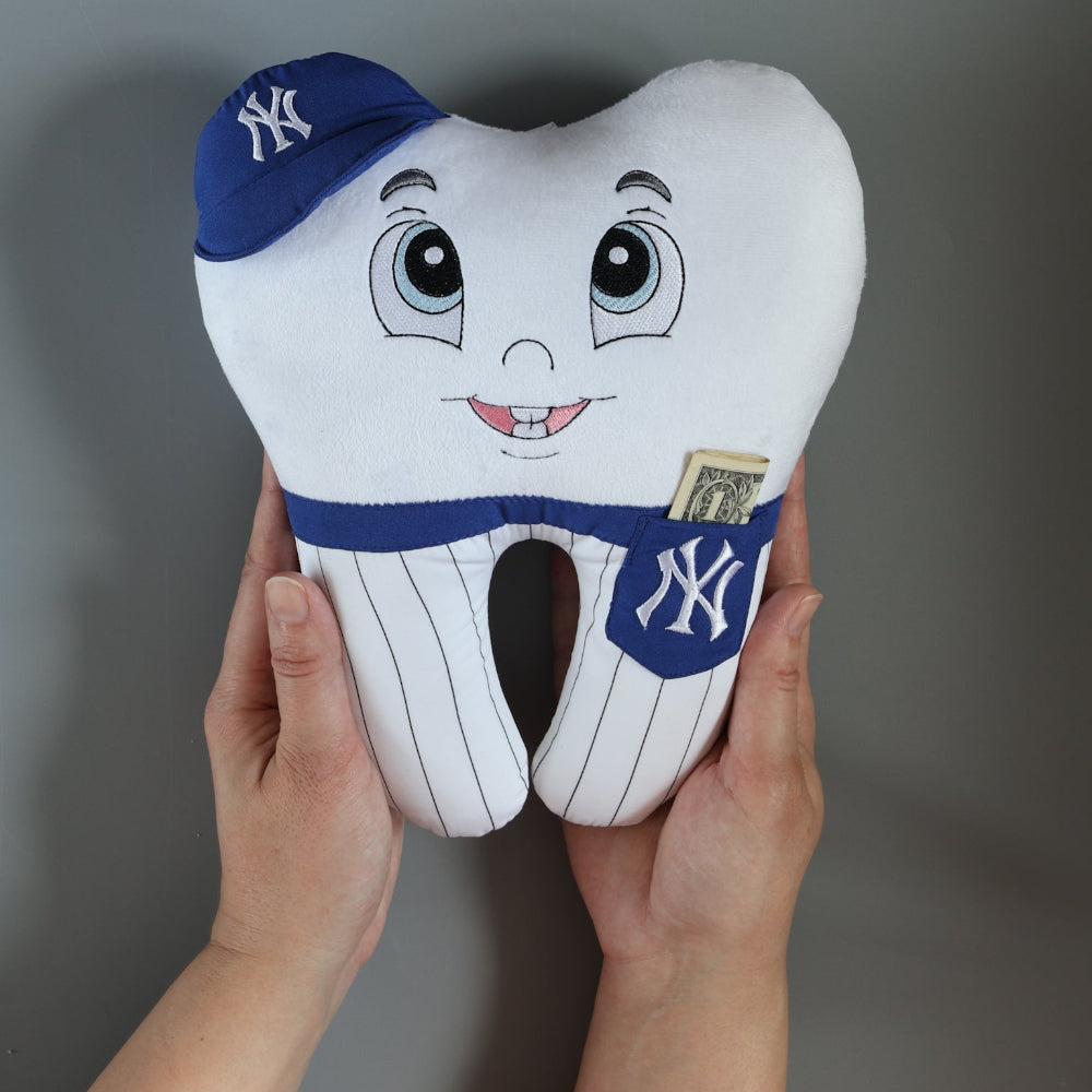 Plush tooth-shaped toy with New York Yankees logo held by hands against a gray background