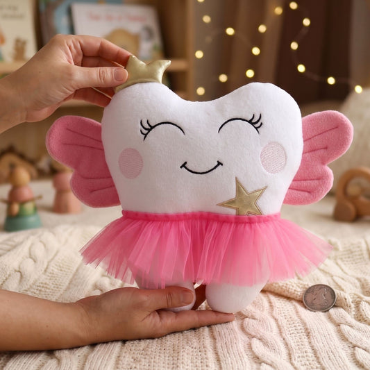 Tooth Fairy pillow with pink wings, a gold crown, star detail, and pink tulle skirt held by hands