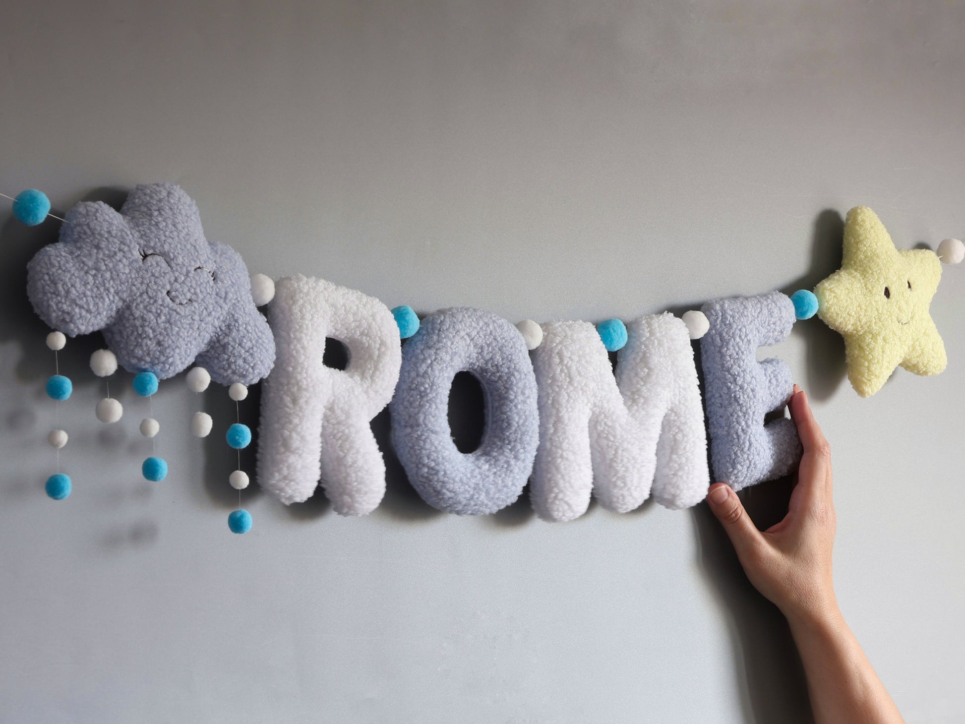 Felt letter banner  with decorative elements on a plain background