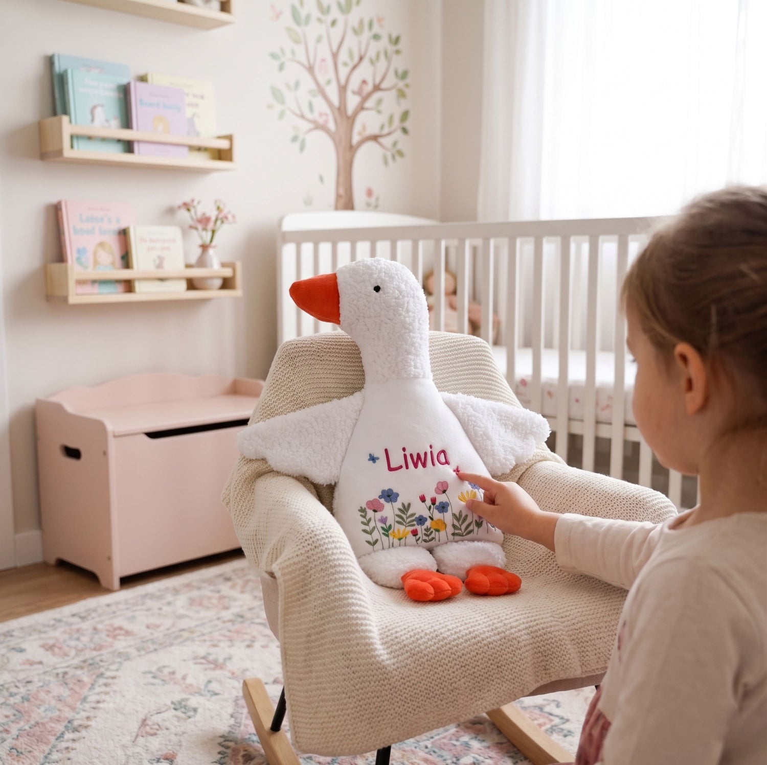 Child holding a personalized stuffed goose toy in a nursery