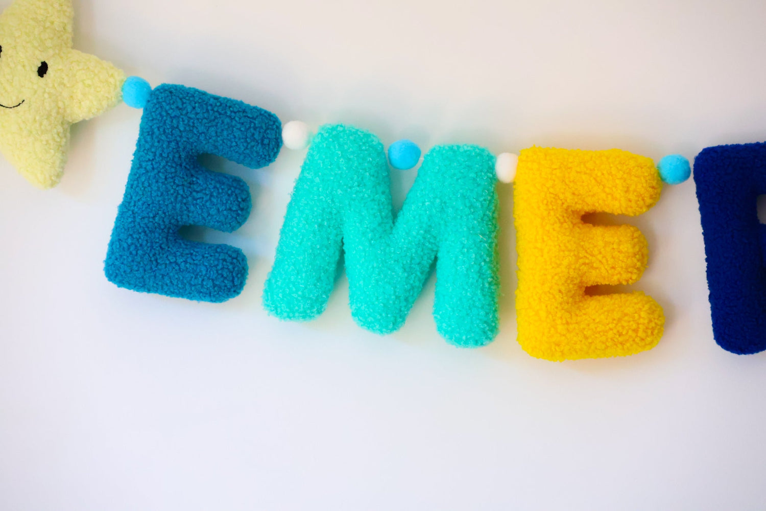 Colorful letter banner with a star-shaped plush toy on a white background